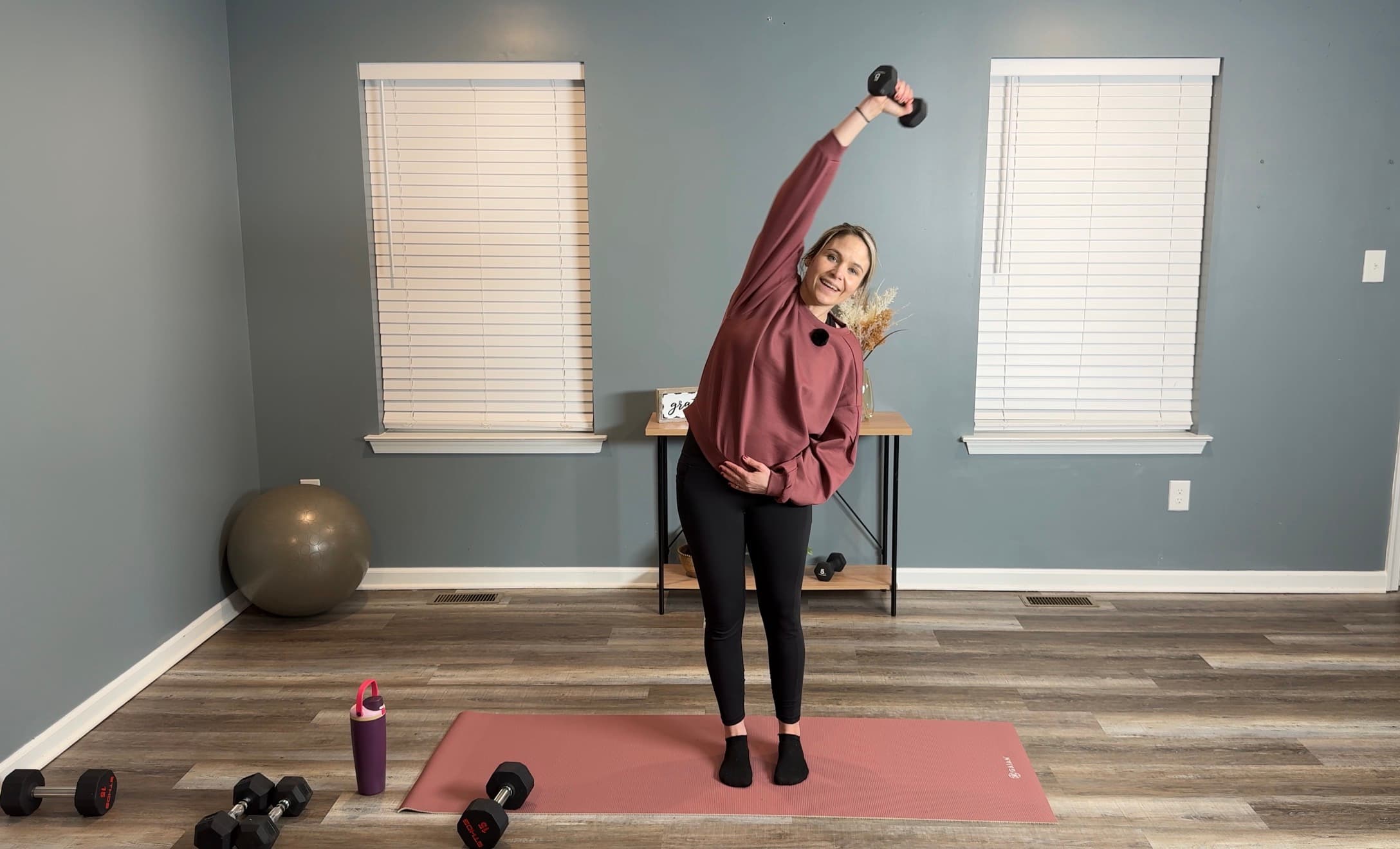 Strong & Steady instructor demonstrating a home exercise with a dumbbell.